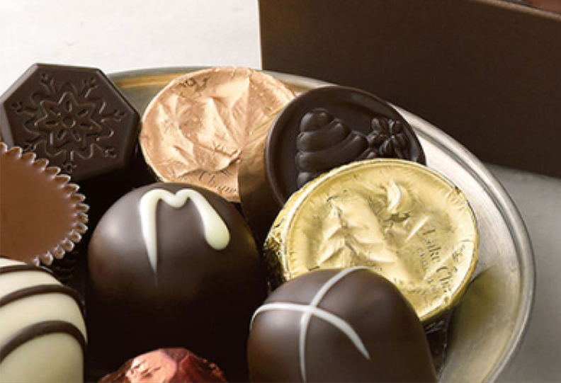 Assorted goutmet chocolates on a ceramic plate.