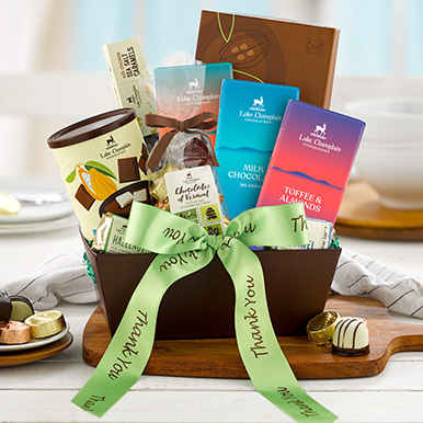 Assorted gourmet chocolates in a brown reuseable gift basket with a green thank you ribbon.
