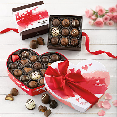 Assorted Valentine's Day gift boxes on a white wooden background.
