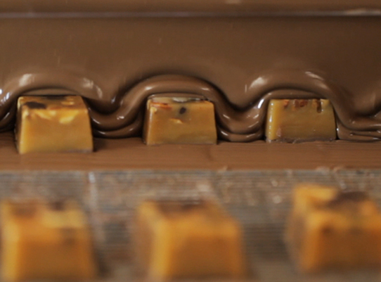 covering Caramel Five Star Bars in milk chocolate