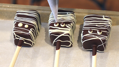 adding chocolate eyes to marshmallow pops