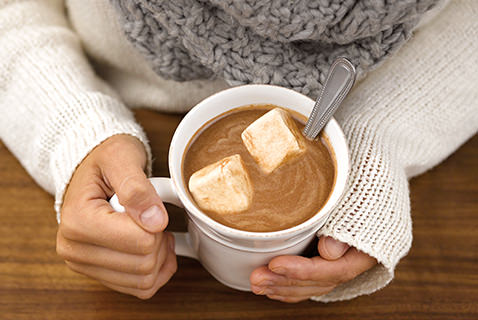 woman holding a mug of hot chocolate with marshmallows