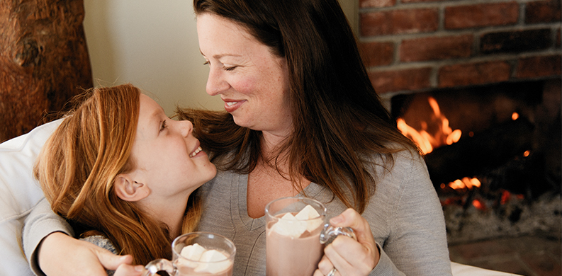 mom and daughter enjoying a mug of hot chocolate