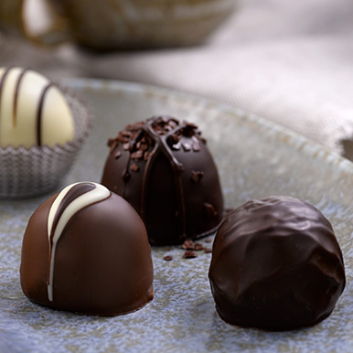 Assorted gourmet chocolate truffles on a glass dish
