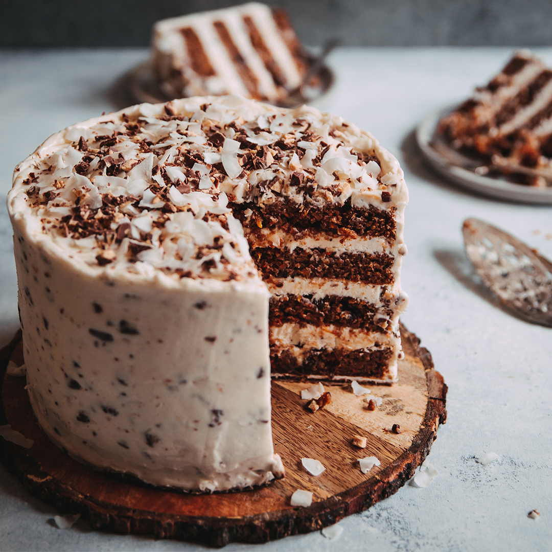 four-layer carrot cake with chunks of chocolate