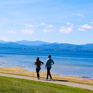 women walking along Lake Champlain