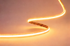 COB RGB LED strip lit in warm orange along a curve volka