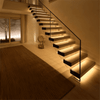 Architectural staircase with intelligent motion sensor LED lighting illuminating each stair tread