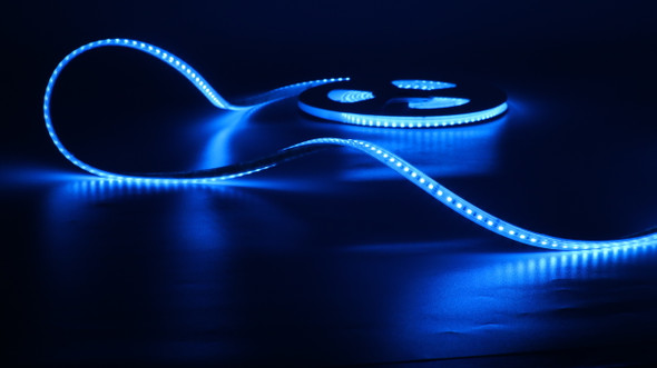 RGB LED strip glowing blue on reel – SMD 3838 120 LEDs per metre 24V IP67 waterproof