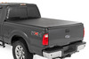 All-Weather Bed Protection: Rough Country's Soft Roll-Up Bed Cover delivers reliable protection against the elements while preserving full bed functionality. Constructed from high-quality, marine-grade vinyl with a sleek matte black finish, this durable cover features heavy-duty hook-and-loop side seals and tight front and rear barriers to shield your cargo from rain, dust, and debris.Streamlined Low-Profile Design: Sitting just 1-1/8" above the bed, this top-mount cover blends seamlessly with your truck's lines for a clean, stylish look. The corrosion-resistant, black powder-coated aluminum frame offers long-lasting strength without sacrificing style or aerodynamics.Fast and Easy Bed Access: The roll-up design and spring-latch closure system make opening and closing the cover a breeze. A single cable pull lets you release the latch quickly, giving you fast access to your full bed whenever you need it. Whether you're hauling gear or unloading tools, convenience comes standard.Effortless Installation: No drilling required - this cover installs in just 20 minutes using the included bracket system and tools. It mounts securely to your factory bed rails for a snug, hassle-free fit you can count on.Protected by a 5-Year Warranty: Rough Country backs this Soft Roll-Up Bed Cover with a 5-Year Replacement Warranty, protecting against structural and workmanship defects so you can hit the road with total confidence.