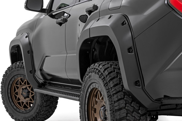 Aggressive Style, Serious Coverage: Give your Toyota 4Runner a commanding new look with Rough Country's Pocket Fender Flares. With 5.75 inches of added flare height and 1.75 inches of extended tire coverage, these flares offer maximum protection against rocks, mud, and road debris on or off the trail. Their rugged flat black finish and bold, pocket-style design instantly upgrade your 4Runner's stance, while the paintable surface lets you customize the look to match your ride perfectly.Engineered for Adventure: Built from high-strength Tri-Blend ABS, these flares are tough enough for whatever terrain you throw at them. Designed exclusively for the third-generation 4Runner, they feature a precision-molded fit and integrated UV protection to prevent cracking, fading, or warping even under harsh sun or trail abuse. Whether you're crawling over rocks or cruising through the city, these flares deliver the durability and style your 4Runner deserves.Easy Install, No Compromise: Install is quick and drill-free thanks to a direct bolt-on design, no cutting, no hassle. Each set includes corrosion-resistant black and silver rivet-style hardware for a rugged custom look. And when it's time to go back to stock, removal is just as easy. Backed by Rough Country's 3-Year Limited Warranty, you'll enjoy peace of mind knowing your upgrade is built to last.Elevate your 4Runner with fender flares that blend function, form, and off-road attitude all in one package.