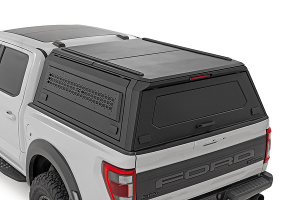 Rough Country's Bed Cap for the Ford F-150 is designed for the serious enthusiast who needs more than basic protection. Featuring full-opening gullwing doors for enhanced accessibility, customizable storage solutions with modular Molle panels and optional shelves, and tough lockable panels for security, this topper ensures your gear stays safe and visible with a third brake light. It includes an integrated LED strip for convenient illumination and is built with a durable stainless steel frame coated with a UV-resistant finish, weather-resistant rubber seals, and heavy-duty latches to keep everything secure in harsh conditions. Perfect for outdoor enthusiasts and contractors, it offers a rugged, feature-packed solution to elevate your truck's storage and functionality.
