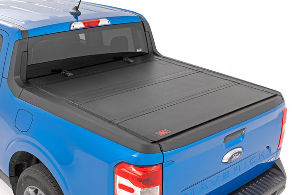 Elevate your Maverick's functionality and appearance with Rough Country's Ford Maverick Hard Tri-fold Flip-up Bed Cover. Unlike traditional bed covers that limit access to your truck bed, our innovative Flip-up design grants you complete access to your truck bed, making it easier to load and unload large items.Full-Bed Access: With Rough Country's Tri-fold Flip-up Bed Cover, you can conveniently flip up the cover, allowing full-bed access without the hassle of removing the cover.Built to Last: Our bed cover is crafted from lightweight aluminum and boasts a resilient powder coat finish. This coating resists corrosion and wear, ensuring that your truck bed maintains its pristine appearance even in harsh weather conditions.Superior Water Drainage System: The bed rails of this bed cover feature an innovative water drainage system. No need to worry about water pooling on your cover or seeping into your truck bed.Premium Weather Seals: The Tri-fold cover also includes top-of-the-line weather-resistant seals that create a tight and secure barrier along the bed rails. These seals ensure your cargo remains protected from the elements, even in inclement weather.p>Secure Cargo Storage: Provide added security for your truck bed contents, deterring theft and protecting valuable items.Elevate your Maverick's bed and get full access, unmatched durability, and superior weather protection with Rough Country's Hard Tri-fold Flip-up Bed Cover!