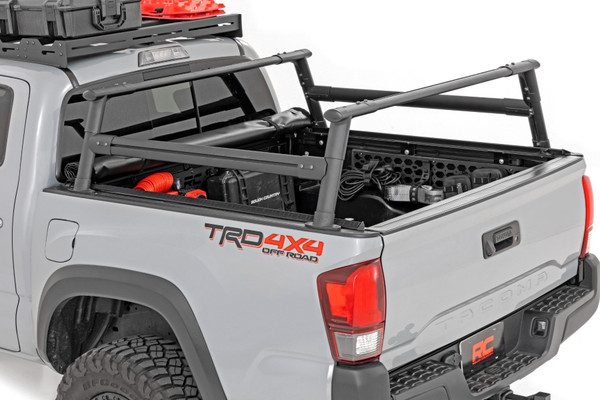 Upgrade your Tacoma Bed. The Tacoma Bed Rack from Rough Country gives you the flexibility to carry bulky cargo and outdoor equipment in your truck bed. It's just right for loading ladders, roof racks, bikes, and more with ease. And whether you're headed out for a camping trip or working under the sun on a job site, this bed rack keeps all your equipment close at hand.\
Durable Style: This innovative bed rack system is built from durable powder-coated aluminum for lightweight strength and durability. The modular design allows you to add as many crossbars as needed, and the molded end caps and T-slot covers give your truck that clean look you're looking for. Rugged enough to handle any payload you can throw at it; our bed rack is sure to turn headsΓÇöand help you carry your gear wherever you need it.\
Installation and Warranty: This easy-to-install rack offers endless mounting options and adjustability, so you can customize it to suit your specific needs. It also retains rear visibility, making it the perfect choice for those who want to maintain a clear view while driving. Plus, it comes with Rough Country's Limited Lifetime Warranty, so you can rest assured that it's built to last. So, load up and hit the road with confidence, knowing that Rough Country has you covered.