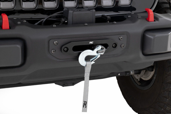 Superior Style. Get ready for off-road adventures with Rough Country's Winch Mounting Plate for the Jeep Wrangler JL 4WD. This stylish recovery solution is hidden behind the OEM modular steel bumper for a sleek look while still providing the functionality you need. The standard 4.5in x 10in 4 bolt mount will accommodate most winches on the market, giving you the versatility to choose the right winch for your needs.\
Heavy-Duty Steel Construction. Rough Country's Winch Mounting Plate is the perfect addition to your JL. With its durable black carbon powder coating and heavy-duty 7GA steel construction, this mounting plate can handle anything the off-road throws at it. It has been engineered NOT to impede airflow to the radiator, so you can tackle any obstacle without worrying about your engine overheating. The flush design leaves only the hawse fairlead and tow hook exposed, giving your Jeep a clean, polished look while ensuring maximum functionality.\
Installation and Warranty. Since the front bumper stays in its stock location, installing our Winch Plate is a breeze and can be completed by just one person. And with Rough Country's commitment to quality, you can have peace of mind with the included Limited Lifetime Warranty.