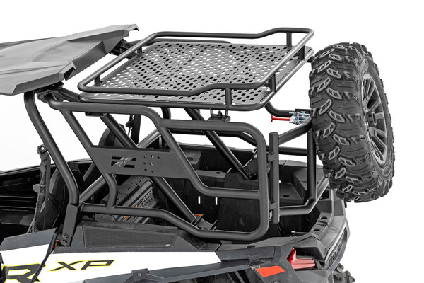 Additional Storage. Carrying a full-size spare with you on your outings is a huge plus, but you can lose that much-needed cargo space when placing it in the bed. Here at Rough Country we keep the adventurist in mind and created Rough Country's Tubular Rear Cargo Rack/Spare Tire Mount for Polaris RZR models.\
Innovative Design. This durable, tubular steel tire carrier is designed to carry a full sire replacement tire, displayed prominently on the rear of your UTV's cargo rack. Each rack features a rear swing out door that allows full access to the bed and a basket up top for additional cargo. This innovative design also utilizes multiple tie-down locations ensuring that you can secure your cargo from every direction. Give your RZR an aggressive look and practical access to a full-sized spare anytime you need it with Rough CountryΓÇÖs Cargo Rack Spare Tire Carrier!\
Installation. With no cutting or drilling required to install, installation couldn't be easier. With an estimated timeframe of 2-3 hours this full kit can be installed at home using standard tools and can be completed efficiently and quickly.\
Limited Lifetime Replacement Warranty. Rough Country's Tubular Rear Cargo Rack is backed with a limited lifetime replacement warranty towards manufacturer defects. As such, the product is protected from structural and workmanship damage after the date of purchase. With our industry-leading warranty give yourself peace of mind when using Rough Country's Suspension products!