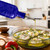 Olive Branch Oil & Vinegar Bottle w/ Pour Spout, 16 oz Cobalt Blue Pouring Olive Oil in Baking Dish with Feta