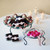 Ribbon Bowl & Stand with Pink and Polka Dot Ribbons, Chocolates, and Boxed Candies by Candles at Event