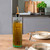 16.9 oz Tuscany Oil or Vinegar Bottle with Gold Spout with Olive Oil on Dining Room Table