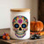 Calavera Sugar Skull Glass Jar w/ Lid, 12 oz, Glossy White on Side Table with Pumpkin, Marigolds, and Black Stones