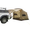 Side angle showing the SJK Slumber Shack 4 Person Tent, tan. Tent is shown completely assembled with awing feature attached to the back of a Toyota pickup with a camper shell.