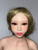 Close-up of the Piper Ariel doll head showing brown eyes, pink lips, painted brows, long lashes, and soft facial makeup with wig.