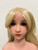 Close-up of the blonde Scarlett WM Doll head showing facial features, eyes, lips, and wig styling.