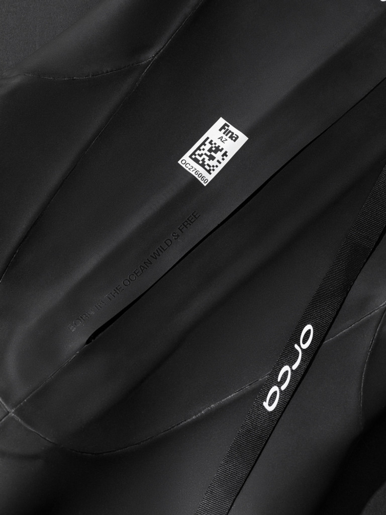Close up of writing on back of Orca Zeal Perform saying 'BORN IN THE OCEAN, WILD & FREE'
