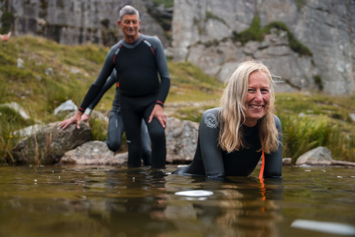 Two people in the lake wearing the ZONE3 Active-Flex, smiling as they begin to submerge themselves