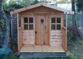 Hideaway children's playhouse with a heart door, available at Cabins Unlimited. 