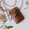 small brown leather crossbody bag with front pockets and long adjustable shoulder strap