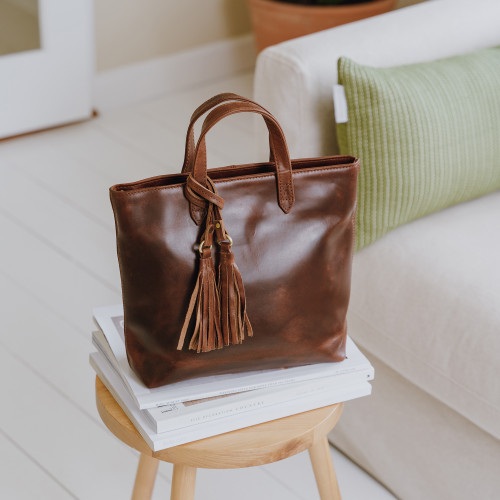 small brown leather grab bag with tassel and long shoulder strap