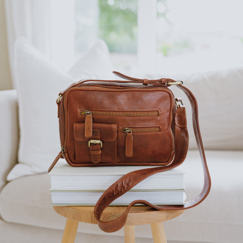 tan vegetable tanned leather handbag with front pockets and adjustable shoulder strap