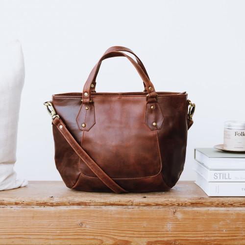 brown leather grab bag with two handles and detachable crossbody strap, worn on model's shoulder