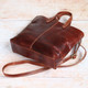 brown leather grab bag with tassels, two handles and crossbody strap