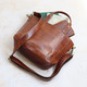 tan leather handbag with two handles and long adjustable crossbody strap