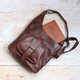 brown leather crossbody bag with large front pocket and long shoulder strap