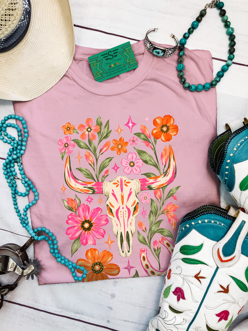 floral steer shirt, floral steer skull shirt, western floral shirt, cow skull graphic tee, western graphic tee, cowgirl graphic shirt, colorful western shirt, pink western shirt, floral cow skull tee, steer skull graphic shirt, western wildflower shirt, boho western shirt, women’s western graphic tee, western boutique shirt, cowgirl floral shirt, rodeo graphic tee, western concert shirt, bright western shirt, trendy cowgirl shirt, western apparel