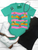 Bright, bold, and full of western spirit, our Life of a Cowboy Vibrant Graphic Tee celebrates the grit, tradition, and excitement of cowboy life. Featuring colorful hand-drawn rodeo scenes—including bronc riding, roping, ranch work, fencing, and western tack—this eye-catching design is finished with playful retro-inspired stripes that make it a true statement piece.
Printed on your choice of Softstyle, Comfort Colors, or a Muscle Tank, this tee is incredibly soft and perfect for rodeos, county fairs, livestock shows, country concerts, or everyday western style. Whether you grew up in the arena or simply love the western way of life, this shirt brings cowboy culture to life with a fun, artistic twist.