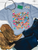 painted ponies shirt, colorful horse graphic tee, western horse shirt, painted horse shirt, cowgirl graphic tee, western floral shirt, colorful western shirt, running horses graphic tee, horse lover shirt, wildflower horse shirt, hand painted horse design, whimsical western shirt, women’s western graphic tee, boho cowgirl shirt, western boutique shirt, rodeo graphic tee, stock show shirt, western concert shirt, bright western shirt, trendy cowgirl tee, floral horse graphic shirt, western fashion