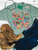 painted ponies shirt, colorful horse graphic tee, western horse shirt, painted horse shirt, cowgirl graphic tee, western floral shirt, colorful western shirt, running horses graphic tee, horse lover shirt, wildflower horse shirt, hand painted horse design, whimsical western shirt, women’s western graphic tee, boho cowgirl shirt, western boutique shirt, rodeo graphic tee, stock show shirt, western concert shirt, bright western shirt, trendy cowgirl tee, floral horse graphic shirt, western fashion