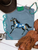blue painted pony shirt, blue horse graphic tee, painted horse shirt, western horse shirt, turquoise horse graphic tee, cowgirl graphic shirt, hand painted horse shirt, blue and white horse shirt, western graphic tee for women, horse lover shirt, artistic horse graphic tee, running horse shirt, colorful western shirt, western boutique shirt, blue western graphic tee, equestrian graphic shirt, rodeo graphic tee, stock show shirt, western concert shirt, trendy cowgirl shirt, country graphic tee, western fashion, painted pony graphic tee