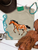 Leopard painted pony graphic shirt, leopard horse graphic tee, western leopard horse shirt, spotted pony graphic tee, leopard print horse shirt, painted pony women's shirt, cowgirl leopard graphic tee, western horse graphic shirt, hand painted horse tee, leopard print western shirt, rustic horse graphic tee, western boutique women's shirt, horse lover graphic tee, animal print horse shirt, western cowgirl clothing, running horse graphic tee, artistic painted horse shirt, orange and brown horse graphic, western rodeo shirt, stock show graphic tee, trendy western women's shirt, boho western horse tee, leopard cowgirl shirt, western equestrian clothing, western boutique graphic tee, Flying S Company