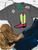 Vibrant check boot graphic shirt, checkered cowboy boot shirt, green check boot shirt, pink cowboy boot graphic tee, colorful western shirt, checkered western boot, western boot graphic tee, bright cowgirl shirt, retro cowboy boot shirt, western boutique women's shirt, cowgirl graphic tee, pink and green boot shirt, trendy western shirt, western rodeo shirt, stock show graphic tee, cowgirl fashion shirt, colorful western clothing, checkered boot graphic tee, cowboy boot shirt, retro western fashion, neon western graphic tee, western boutique clothing, Flying S Company