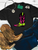 Turn up the heat on your western wardrobe with our Flame Boot Graphic Shirt! This bold and edgy design features a colorful cowboy boot with a black shaft covered in hot pink flames, a bright lime green foot, and vibrant pink and green accents. The hand-drawn, retro-inspired artwork gives this boot a fun, standout look that's perfect for cowgirls who love a little attitude!

Whether you're headed to a rodeo, stock show, country concert, or just living that western life, this flame boot graphic tee is the perfect way to show off your colorful cowgirl style. Pair it with your favorite denim, cowboy boots, and turquoise jewelry for an effortlessly bold and trendy western look!
