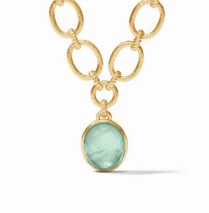 Julie Vos statement necklace featuring a showstopping oval gemstone dangling from a chain of hammered ovals linked by loops of twisted golden rope and closing with a spiral toggle. Julie Vos statement necklace featuring a showstopping oval gemstone dangling from a chain of hammered ovals linked by loops of twisted golden rope and closing with a spiral toggle.