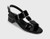 T-strap sandal with illusion vinyl. Buckle with hidden elastic insert. Padded insole. 1.5 inch covered block heel with metallic trim.