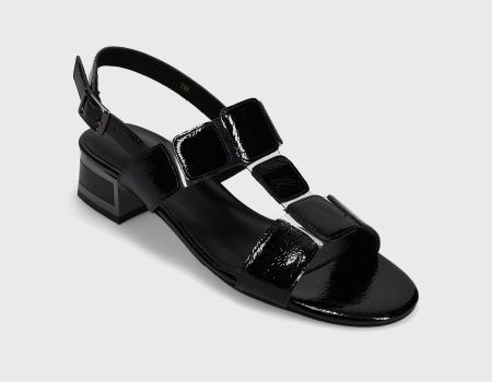 T-strap sandal with illusion vinyl. Buckle with hidden elastic insert. Padded insole. 1.5 inch covered block heel with metallic trim.