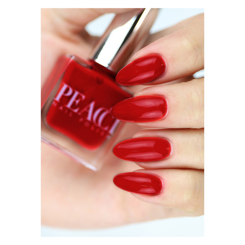 Hand model holding Peacci Chili by The GelBottle Inc., showcasing the vivid neon-red shade on almond-shaped nails.
