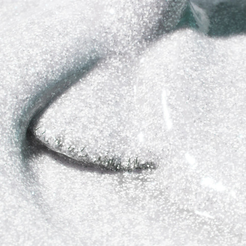 Nail brush sweeping through frosted flashing white holiday gel polish represented as Polar by The GelBottle Inc. Made 100% TPO-free with salon-quality finish